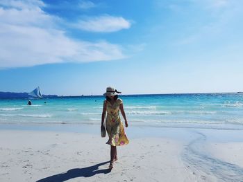 Woman on beach against sky