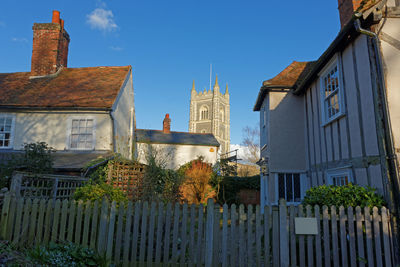 Fenced in houses against blue sky