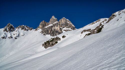 Scenic view of snowcapped mountains against clear blue sky