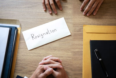 High angle view of hand holding text on table