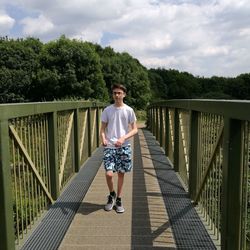 Full length of boy walking on footbridge