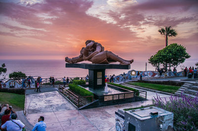 Statue by sea against sky during sunset