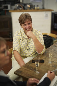 Women with notebook and champagne glass on table