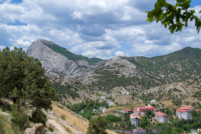 Scenic view of mountains and buildings against sky