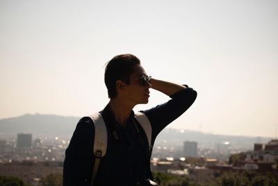 Portrait of man standing against cityscape during sunset