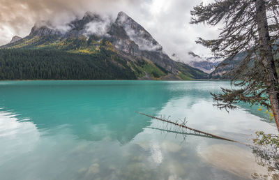 Scenic view of lake by mountains against sky