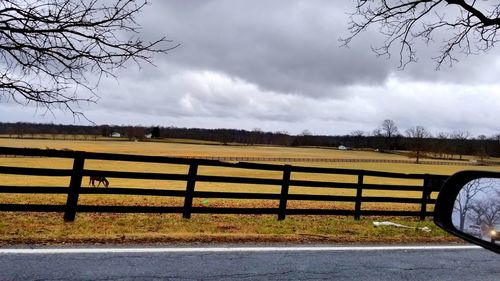 Road in field against cloudy sky