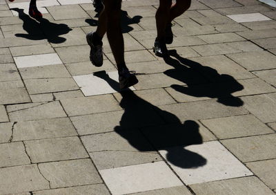 Shadow of people on sidewalk
