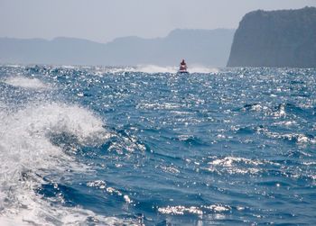 Scenic view of watercraft in sea against sky