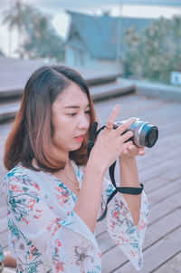 Young woman photographing with mobile phone