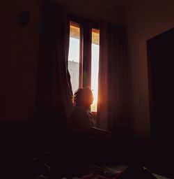 Man looking through window at home