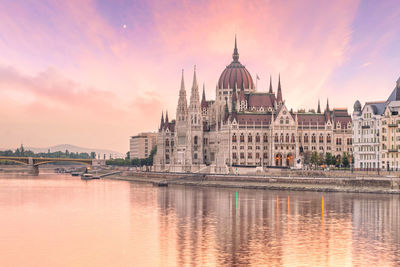 Historical buildings at waterfront during sunset