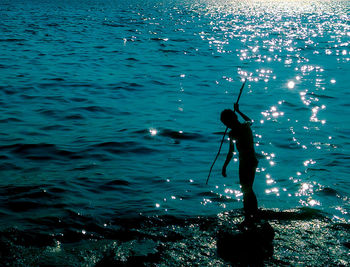 Boy fishing in sea