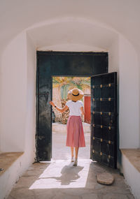 Full length of woman standing against door