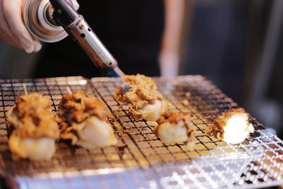 Close-up of preparing food on barbecue grill