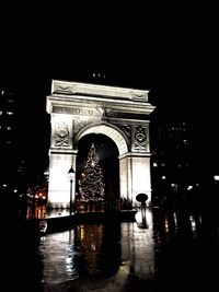 Illuminated christmas tree seen from washington square arch at night