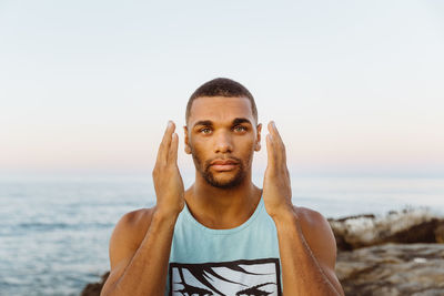 Engaging portrait of male athlete with hands next to his cheeks