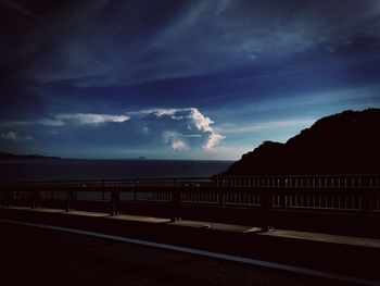 Empty road by sea against sky