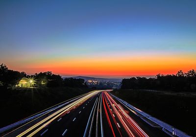 Light trails on highway at sunset