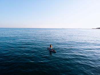 Man in sea against clear sky