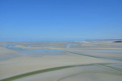 Scenic view of desert against clear blue sky