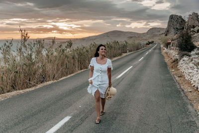 Full length of woman on road against sky