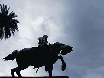 Low angle view of statue against cloudy sky