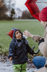 Mother cleaning daughter face at park