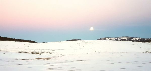 Scenic view of snowcapped mountains against sky during sunset