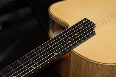 Cropped image of guitar on bed