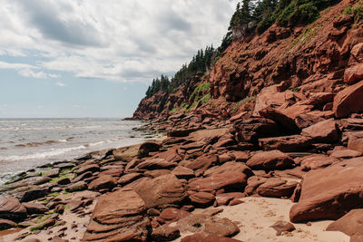 One distant man walking on rocky seashore