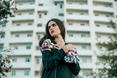 Beautiful woman standing against building in city