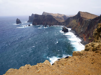 High angle view of rocky coastal feature against sky