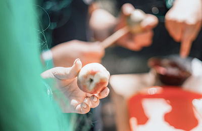 Cropped hand of woman holding apple at market