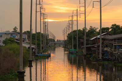 Bridge over canal against sky during sunset