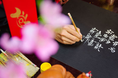 Cropped hand writing on slate