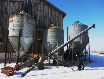 Rusty silos on snow covered field