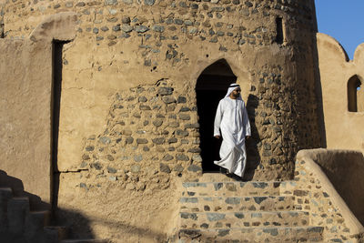 Full length of man standing against wall