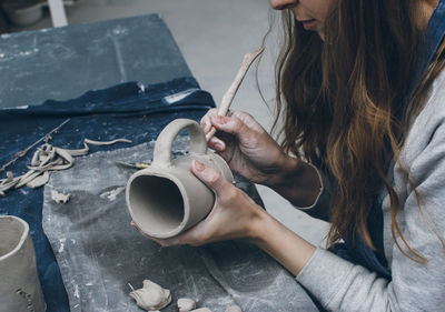 Midsection of woman making clay cup