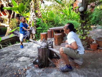 Father and son playing on seesaw at park