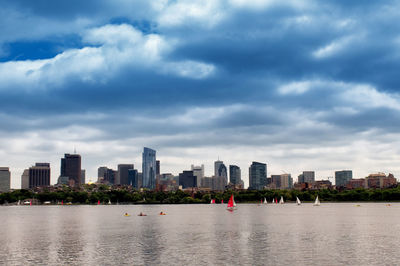 Sea and buildings in city against sky