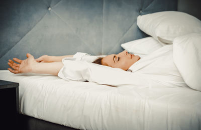 Midsection of woman lying on bed