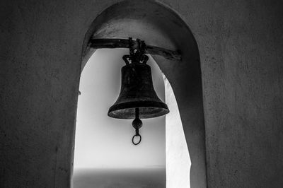 Low angle view of cross hanging on wall