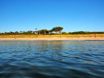 Scenic view of lake against clear blue sky
