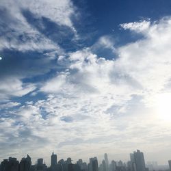 View of cityscape against cloudy sky