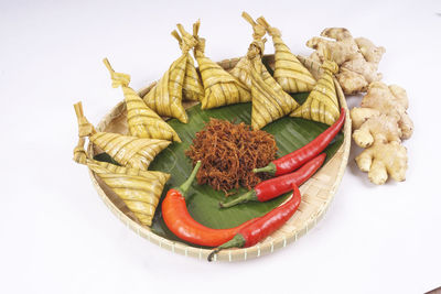 High angle view of vegetables in plate against white background