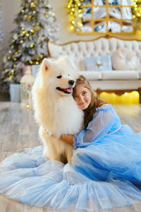 Nice girl in a light blue dress with white samoyed dog