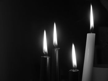 Close-up of lit candles in darkroom