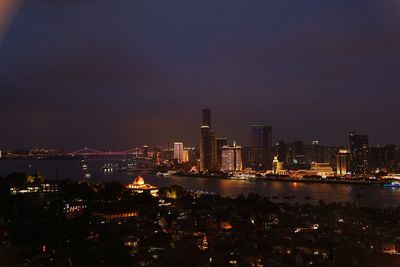 Illuminated buildings in city against sky at night