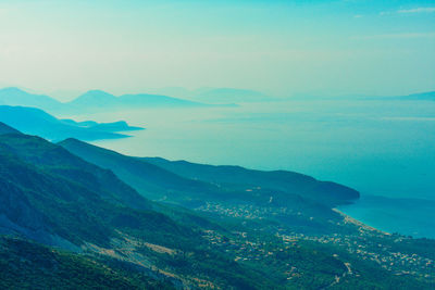 Scenic view of sea and mountains against sky